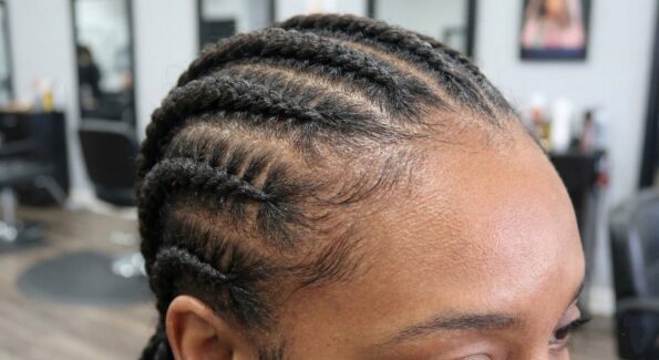 Close-up of tight Ghana weaving cornrows showing tension on the hairline